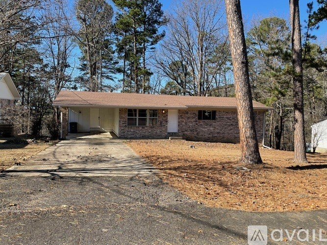 A house with a brown roof is surrounded by trees.