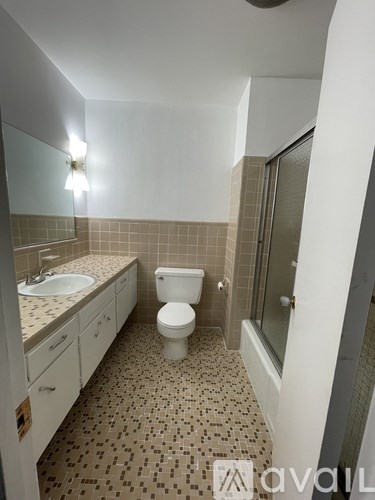 A bathroom with a toilet, sink, and shower.