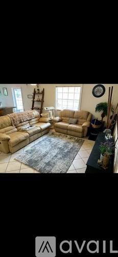 A living room with a beige sofa and a rug.