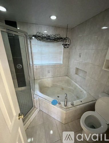 A bathroom with a glass shower door and a bathtub.
