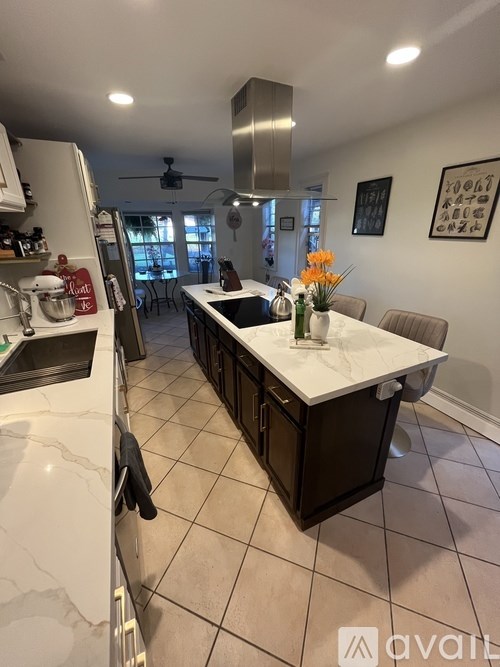 A kitchen with a white countertop and black cabinets.