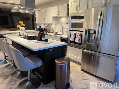 A modern kitchen with stainless steel appliances and a marble countertop.