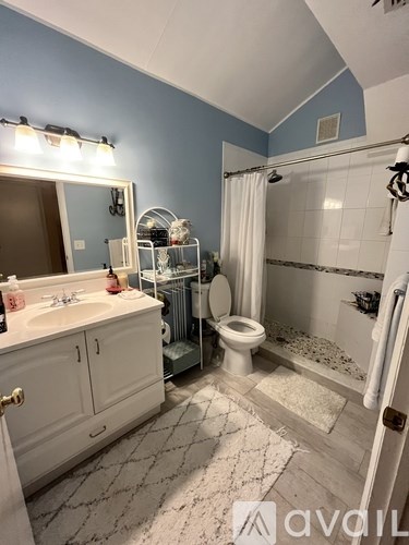 A bathroom with blue walls and white fixtures.