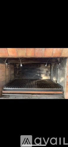 A brick oven with a metal grate inside.
