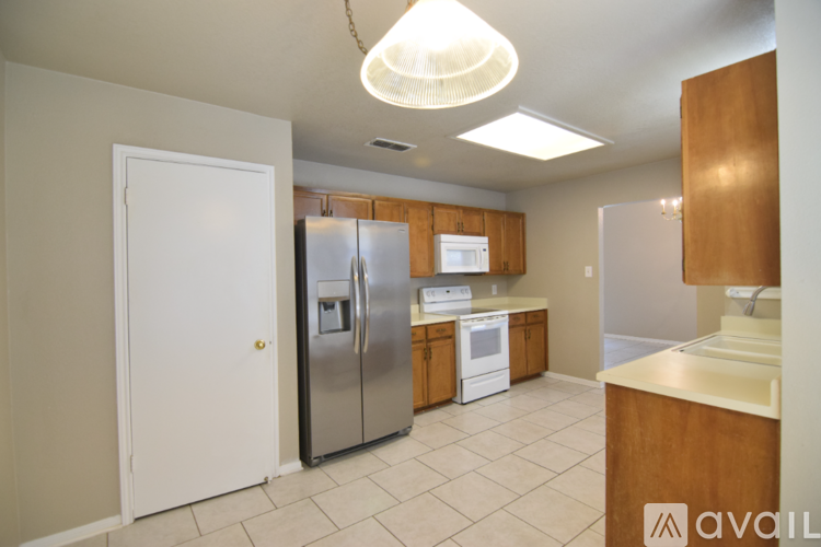 A kitchen with a white refrigerator and wooden cabinets.