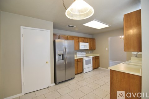 A kitchen with a white refrigerator and wooden cabinets.