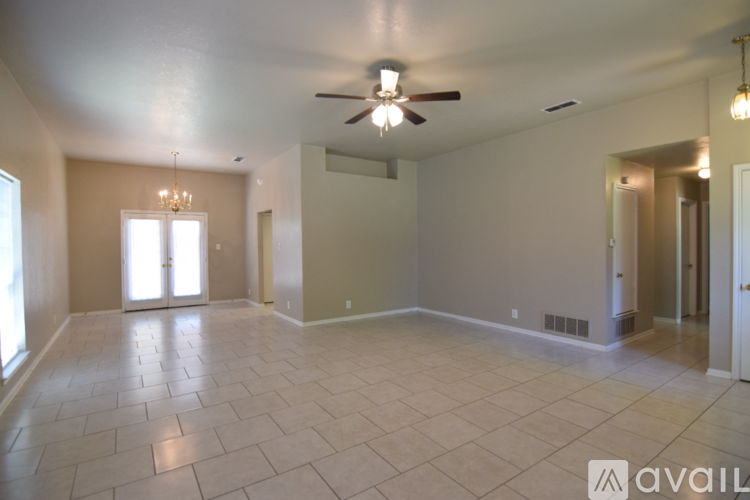 A spacious living room with a fireplace and a chandelier.