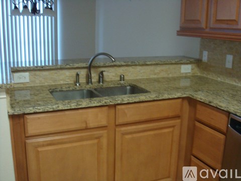 A kitchen with wooden cabinets and a granite countertop.