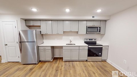 A kitchen with white cabinets and a stainless steel refrigerator.