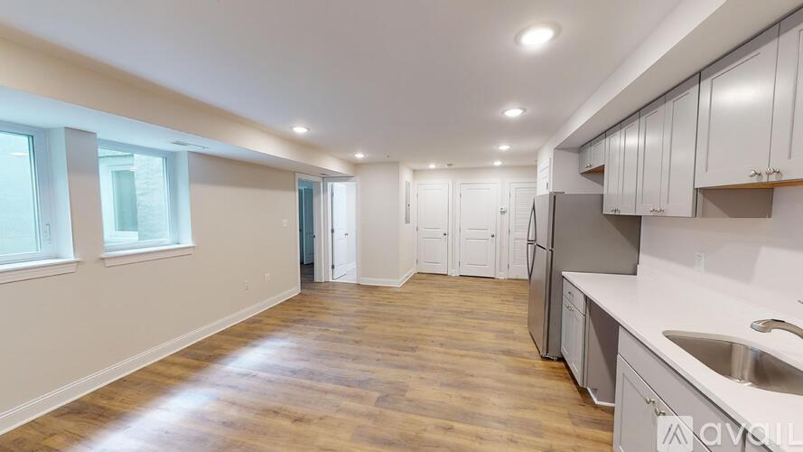 A kitchen with wooden floors and white cabinets is available.