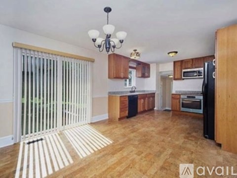 A kitchen with wooden floors and a chandelier.