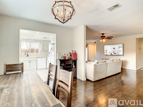 A living room with a white couch and a wooden dining table.