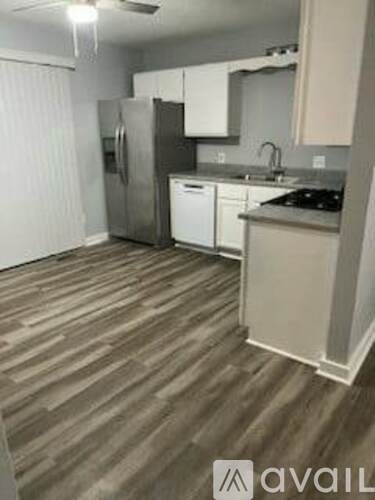 A kitchen with a refrigerator, dishwasher, and stove top oven.
