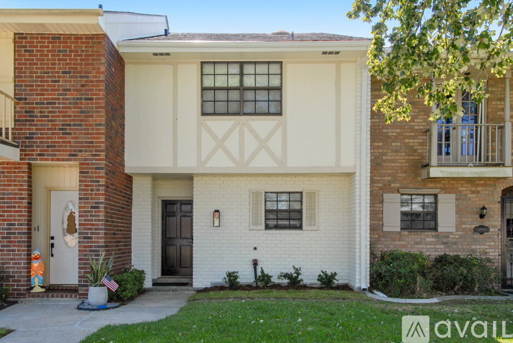 A two-story house with a white front door and a brick facade.