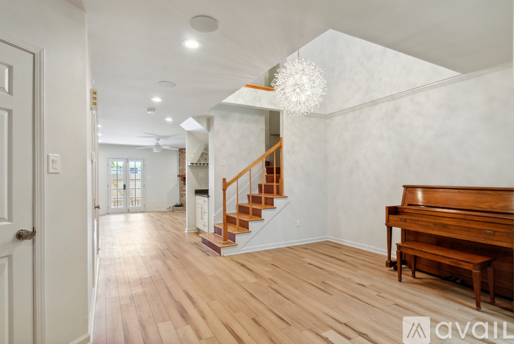 A room with a wooden floor and a grand piano.
