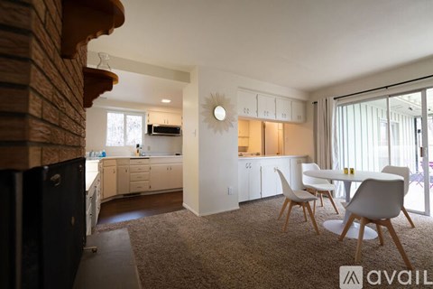 A kitchen with a dining table and chairs in the foreground.