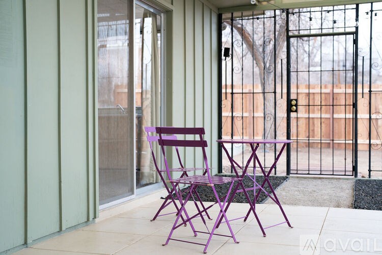 A purple chair and table are on a patio.
