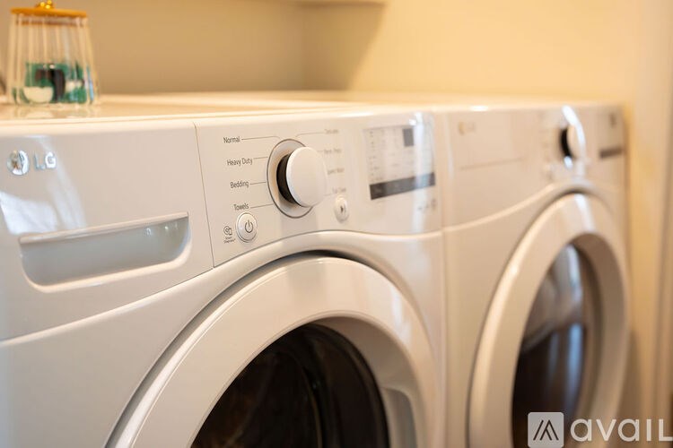 Two white front loading washing machines with control panels.