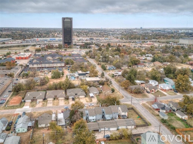 A tall building stands in the distance behind a residential area.
