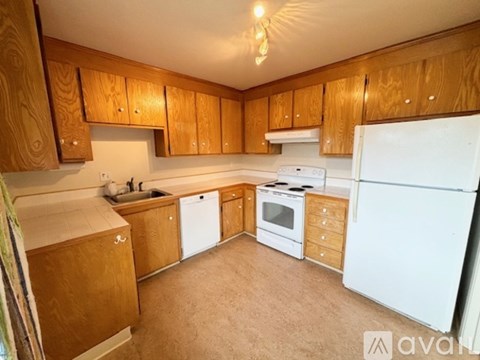A kitchen with wooden cabinets and white appliances.