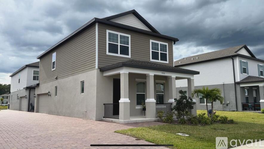 A house with a grey and brown exterior and a black gate.