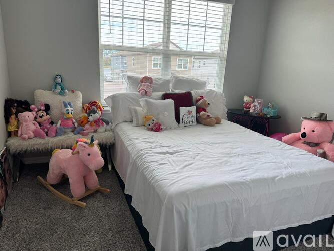 A bedroom with a white bed and a rocking horse.