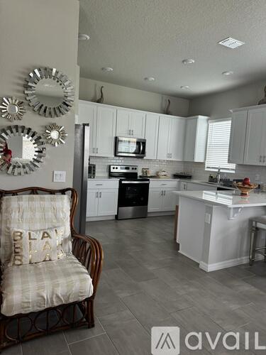 A kitchen with a chair and a wreath on the wall.