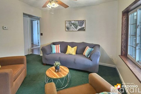 A living room with a grey couch and a wooden coffee table.