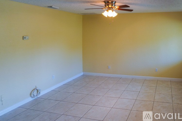 A room with a ceiling fan and tiled floor.