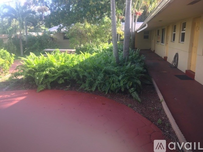 A red pathway leads to a building with a white door.