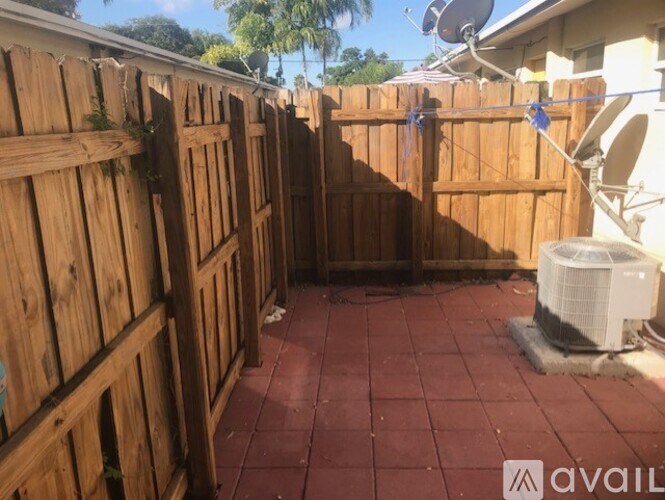 A backyard with a wooden fence and a satellite dish.