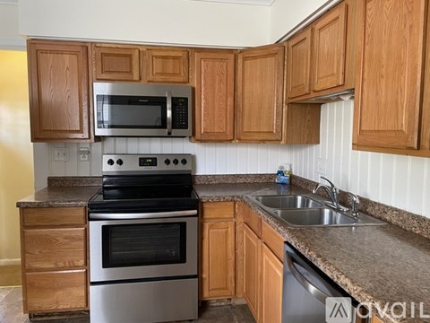 A kitchen with wooden cabinets and a granite countertop.