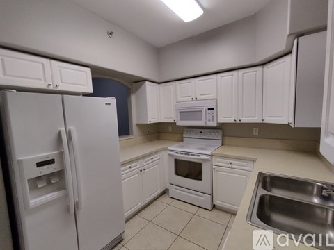 A kitchen with white appliances and cabinets.