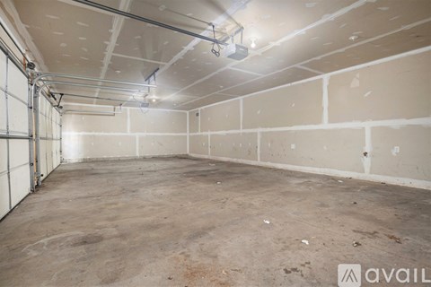 A large, empty room with a concrete floor and walls, and a few electrical fixtures.