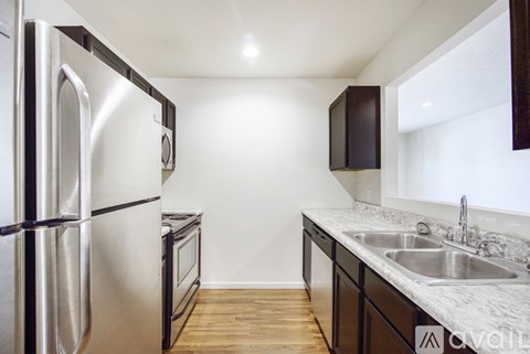 A kitchen with a stainless steel refrigerator and a white countertop.