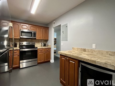 A kitchen with wooden cabinets and granite countertops.