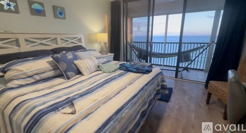 A bedroom with a large bed and a hammock overlooking the ocean.