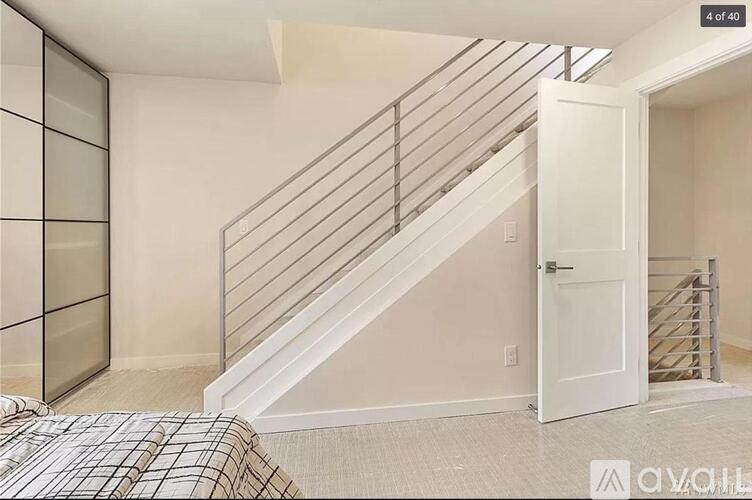 A bedroom with a bed and a staircase.