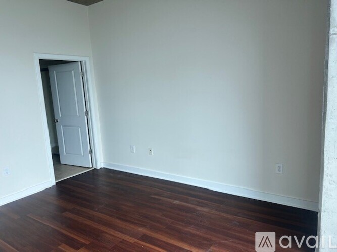 A room with a door and wooden flooring.