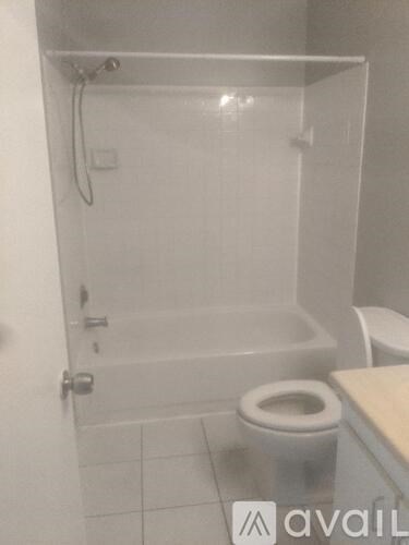 A white bathroom with a toilet and a walk in shower.