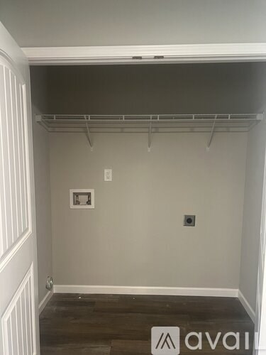 A room with a grey wall and a white door.
