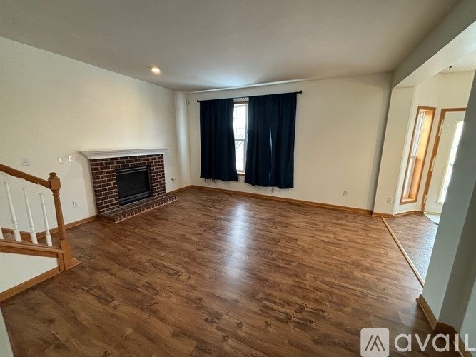 A living room with a fireplace and wood flooring.