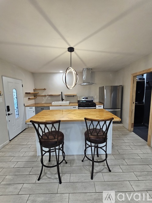 A kitchen with a wooden table and two chairs.
