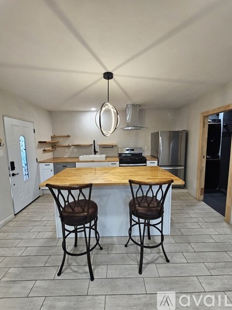 A kitchen with a wooden table and two chairs.