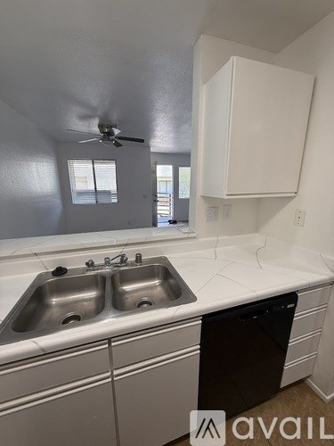 A kitchen with a sink and a fan.