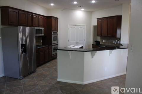 A kitchen with a refrigerator, oven, and microwave.