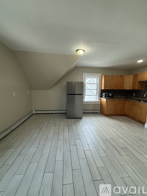A kitchen with wooden cabinets and a refrigerator.