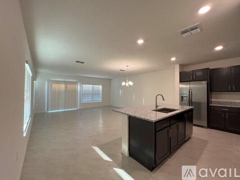 A kitchen with a black countertop and a refrigerator.