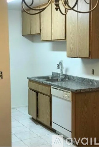 A kitchen with wooden cabinets and a white dishwasher.