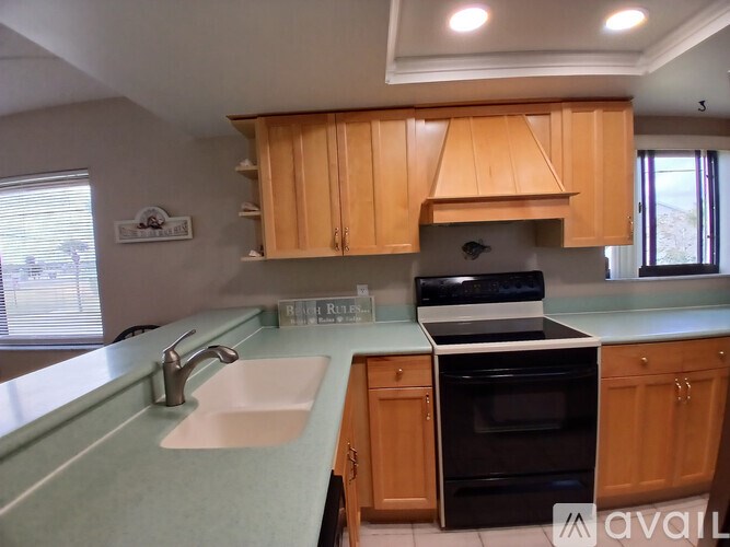 A kitchen with wooden cabinets and a black oven.